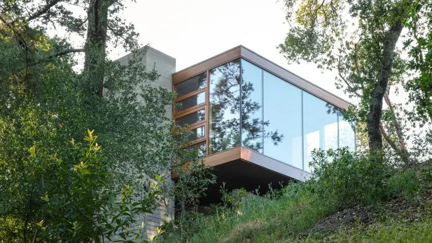 Moss Rock glass box home office by Swatt + Partners floating above California forest